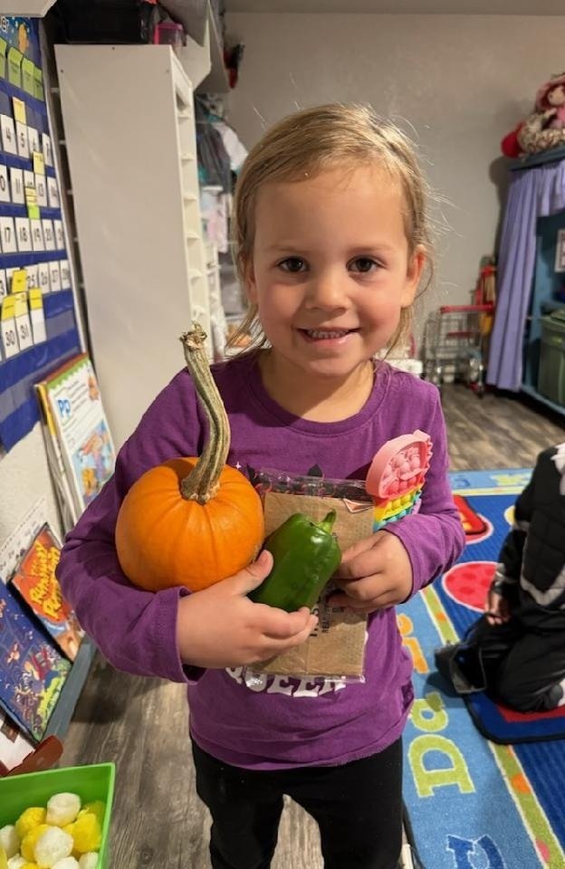 Girl holding a pumpkin, pepper & pop it toy