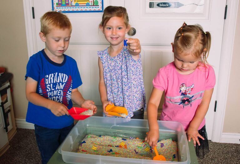 3 children playing at a sensory bin